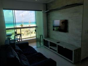 a living room with a couch and a flat screen tv at FORTE DA PRAIA in Cabo Frio