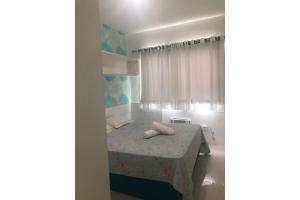 a room with a bed with a table and a window at FORTE DA PRAIA in Cabo Frio