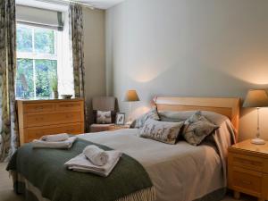 a bedroom with a bed with towels on it at 4 The Old Vicarage in Far Sawrey