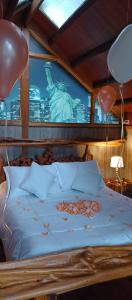 a bed with balloons and a poster of the statue of liberty at Cabaña en la Calera Cerezos in La Calera