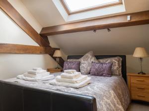 a bedroom with a bed with towels on it at Plas Iwrwg Granary - 28091 in Tal-y-Cafn