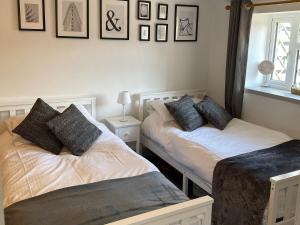 2 Betten in einem Zimmer mit Bildern an der Wand in der Unterkunft Fell Cottage in Marsett