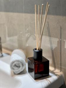 a bathroom with a towel and a vase with sticks at moor-home Studio Apartment in Ganderkesee