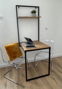 einen Schreibtisch und einen Stuhl mit Laptop in der Unterkunft moor-home Studio Apartment in Ganderkesee