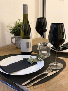 una mesa con una botella de vino y dos copas en moor-home Studio Apartment en Ganderkesee
