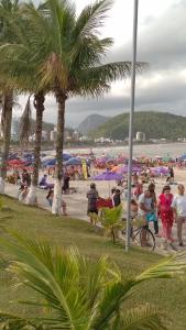 un groupe de personnes sur une plage avec parasols dans l'établissement Brisa do Mar Guaratuba, à Guaratuba