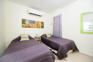 duas camas num quarto com cobertores roxos em HYGGE FORMOSA em Formosa