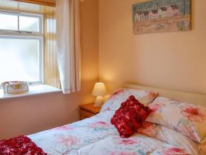 a bedroom with a bed and a window at Freya Cottage in Flamborough