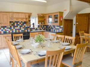 a kitchen with a table with plates and glasses on it at Somersal Farmhouse in Somersal Herbert