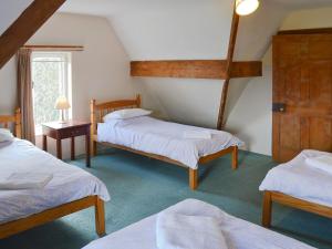 a room with three beds and a window at Somersal Farmhouse in Somersal Herbert