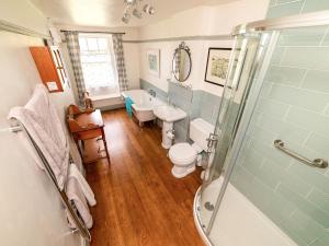 a bathroom with a toilet and a sink and a shower at Corner House in Lorton