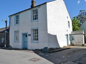 un edificio blanco con una puerta azul en una calle en Corner House, en Lorton