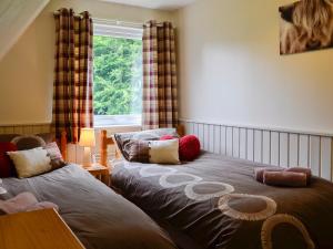 a bedroom with two beds and a window at Glenlivet View in Auchnastank