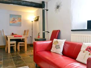 a living room with a red couch and a table at Beck Edge in Braithwaite