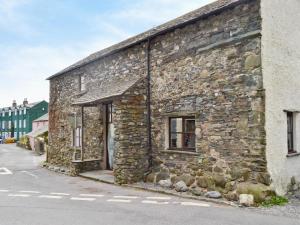an old stone building on the side of a street at Beck Edge in Braithwaite