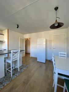 cocina con nevera blanca, mesa y sillas en Apartamento Arce II en al Valle de Benasque, en Castejón de Sos