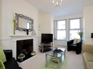 a living room with a fireplace and a tv at Chesil View House in Portland