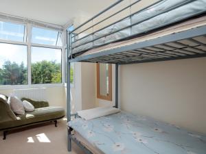 ein Schlafzimmer mit einem Etagenbett und einem Sofa in der Unterkunft Chesil View House in Portland