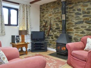 a living room with a stone wall with a wood stove at Ross in Launceston