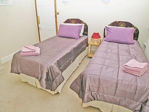 two beds sitting next to each other in a room at Ivy Cottage in Westgate-on-Sea