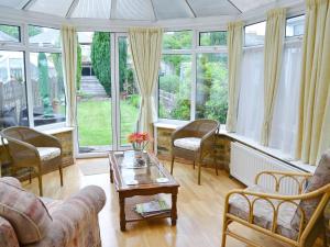 a living room filled with furniture and large windows at Ivy Cottage in Westgate-on-Sea