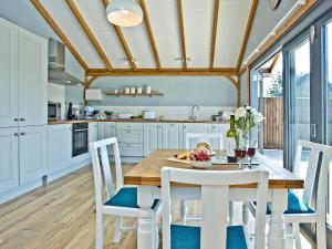 eine Küche mit weißen Schränken sowie einem Holztisch und Stühlen in der Unterkunft Woodland View Lodge in Hawley Bottom