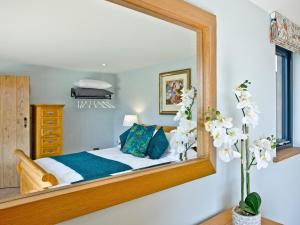 a mirror in a bedroom with a bed in it at Woodland View Lodge in Hawley Bottom