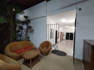 a living room with wicker chairs and a couch at Hotel Cañada Internacional in Palenque