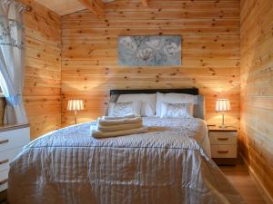 BanavieにあるCruachan Log Cabinの木造キャビン内のベッド1台が備わるベッドルーム1室を利用します。