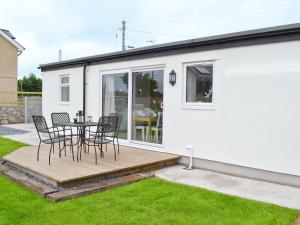 een terras met stoelen en een tafel bij Llifon in Llanwnda