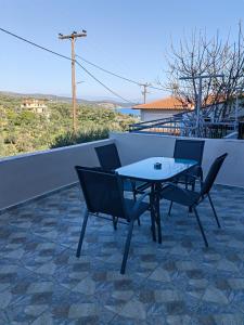a table and chairs on a patio with a view at Mimosa House in Gythio
