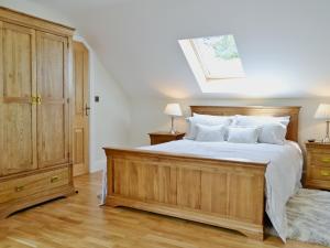 a bedroom with a large wooden bed with white pillows at The Stable - Om4 in Mydroilin