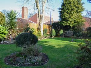 a garden with a bench in the middle of a yard at Pams Plaice in Offord Cluny