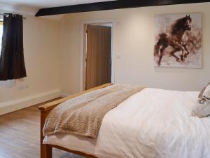 a bedroom with a bed and a painting on the wall at Horseshoe Cottage in Alkham