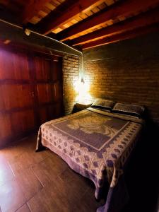 a bedroom with a bed in a brick wall at Renacer in Malargüe