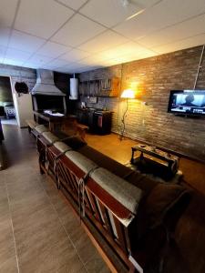 a living room with a couch and a wall with a tv at Renacer in Malargüe