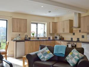 a living room with a couch and a kitchen at The Coop - Prrk in Kirdford