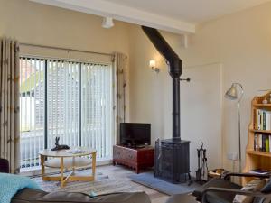 a living room with a wood stove in a room at The Coop - Prrk in Kirdford