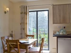 a dining room with a table and chairs and a window at The Coop - Prrk in Kirdford