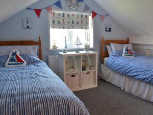 1 Schlafzimmer mit 2 Betten und einem Fenster in der Unterkunft Encil-y-mor in Criccieth