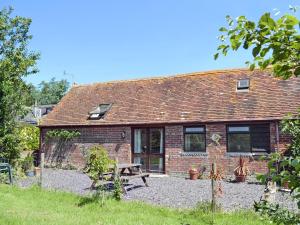 a brick cottage with a picnic table in front of it at High House Holiday Cottages 1 in Hooe