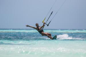 een vrouw op een surfplank in het water bij Wing Camp in Cabarete