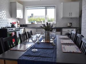 a kitchen with a table with wine glasses on it at Encil-y-mor in Criccieth