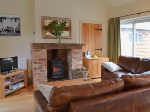 a living room with a couch and a fireplace at Jumbos Stable in Alderminster