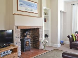 a living room with a fireplace and a tv at Caberfeidh in Grantown on Spey