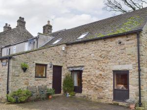 an old stone house with a patio in front of it at Ladycroft Barn in Bamford