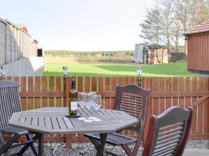 a wooden table with glasses and a bottle of wine at Shedend in Kingston