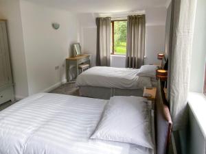 Saint CleerにあるRosecraddoc Manor - Riverbankのベッドルーム1室(ベッド2台、窓付)