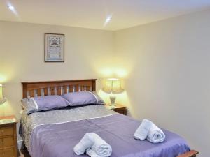 Un dormitorio con una cama morada con toallas. en Strand Cottage, en Seahouses