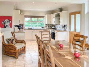 a kitchen with a large wooden table and chairs at Storrs Croft in Arkholme